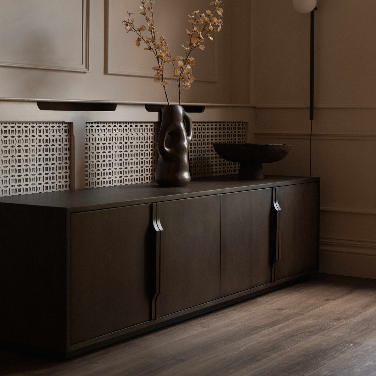 A mid-century modern TV media unit with four doors in a dark brown wood finish, featuring slim vertical handles.