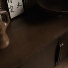 A mid-century modern TV media unit with doors in a dark brown wood finish, featuring slim vertical handles.
