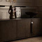 A mid-century modern TV media unit with doors in a dark brown wood finish, featuring slim vertical handles.