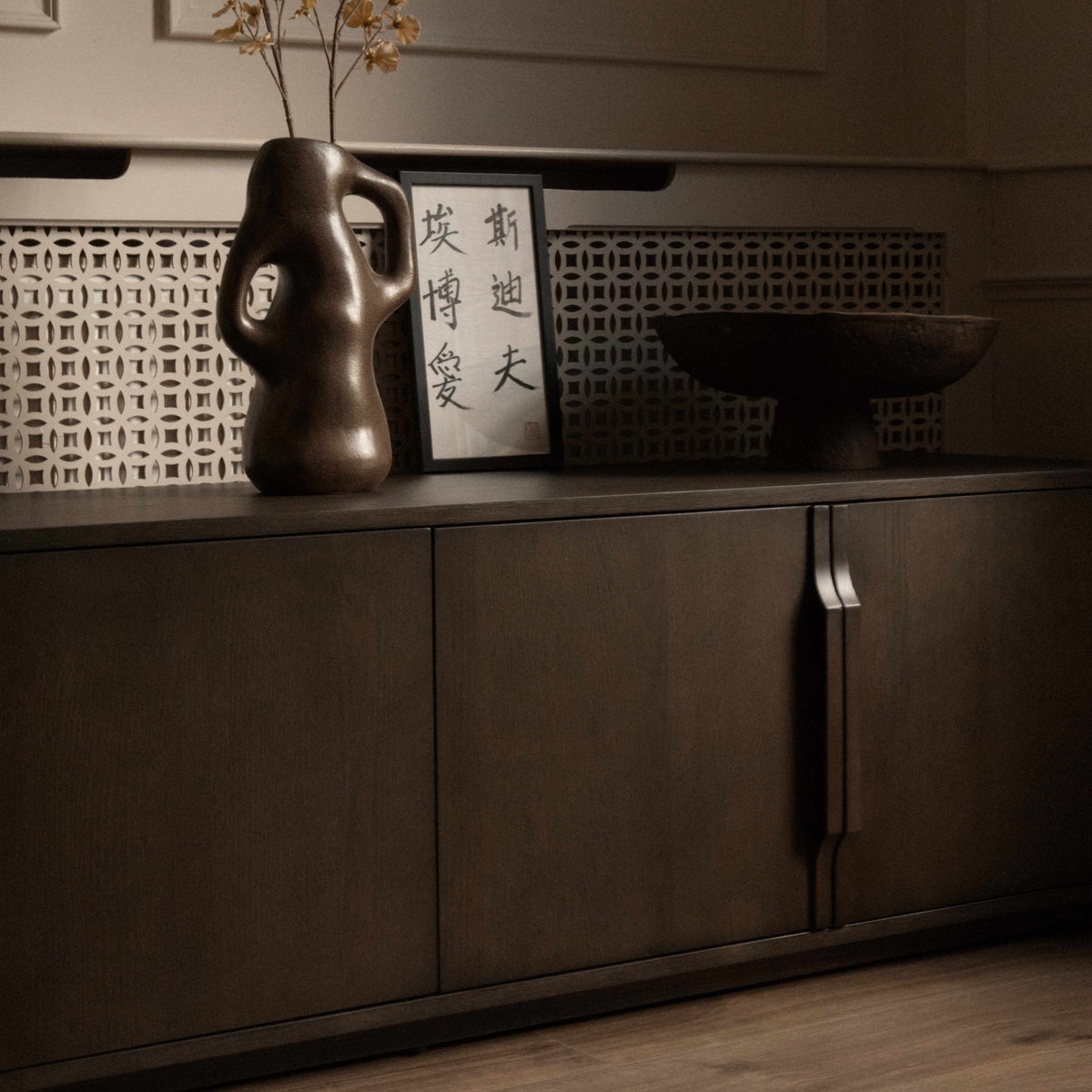 A mid-century modern TV media unit with doors in a dark brown wood finish, featuring slim vertical handles.