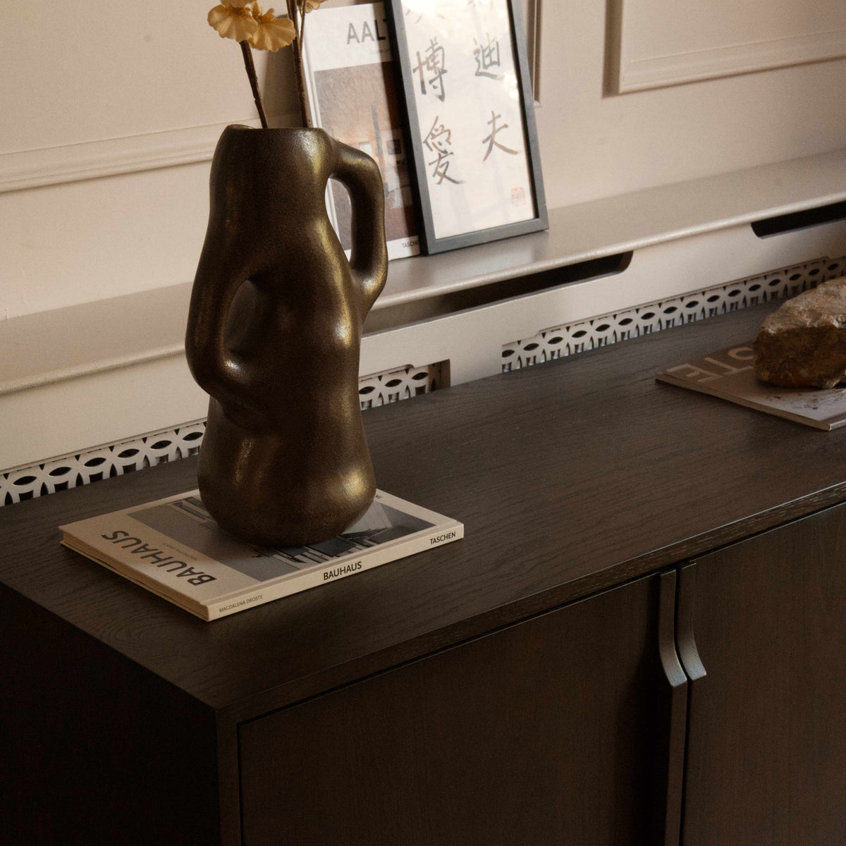 A modern four-door sideboard cabinet in dark brown wood with slim vertical handles.