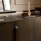 A modern four-door sideboard cabinet in dark brown wood with slim vertical handles.