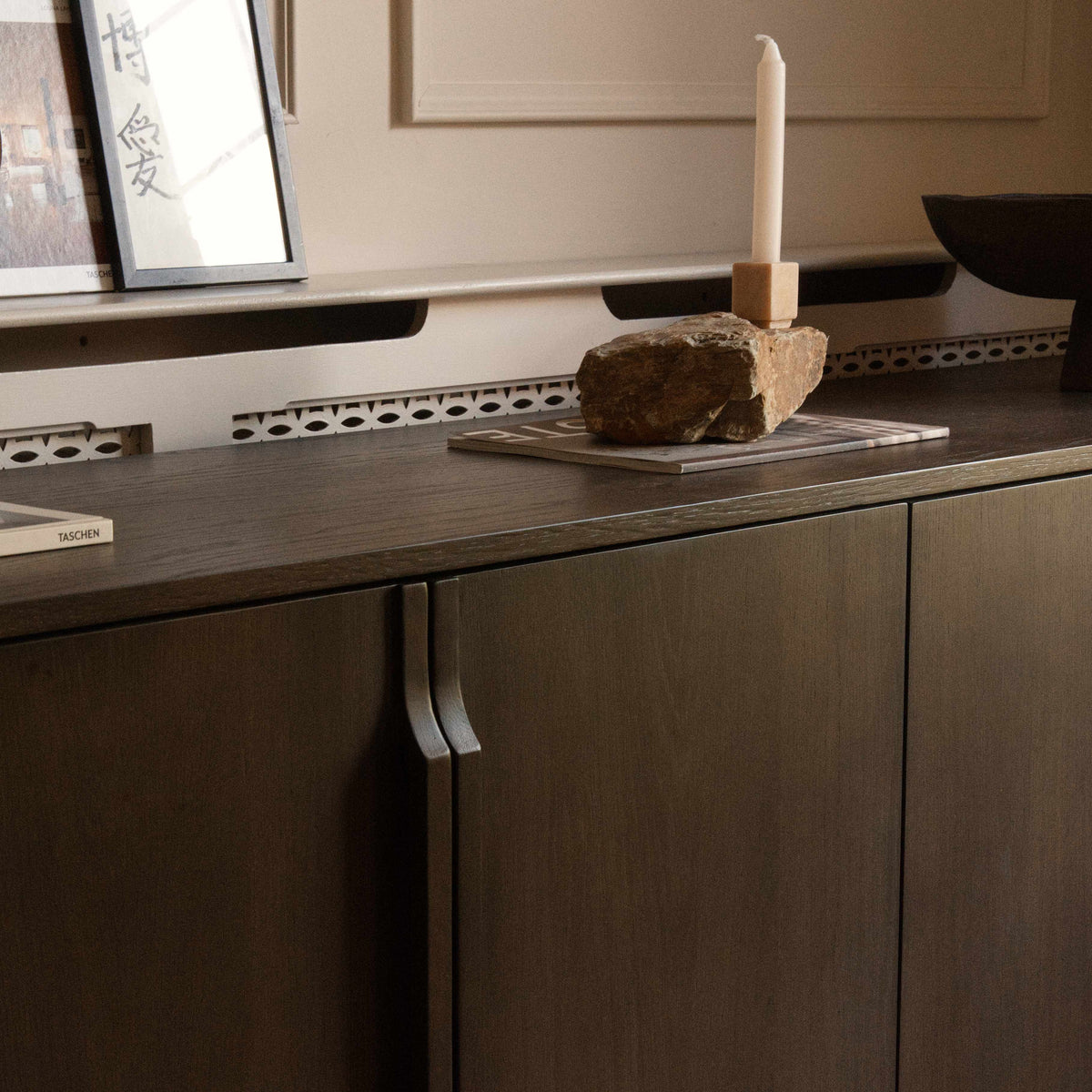 A modern four-door sideboard cabinet in dark brown wood with slim vertical handles.